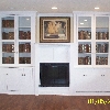 Painted white maple built ins surrounding electric fireplace.